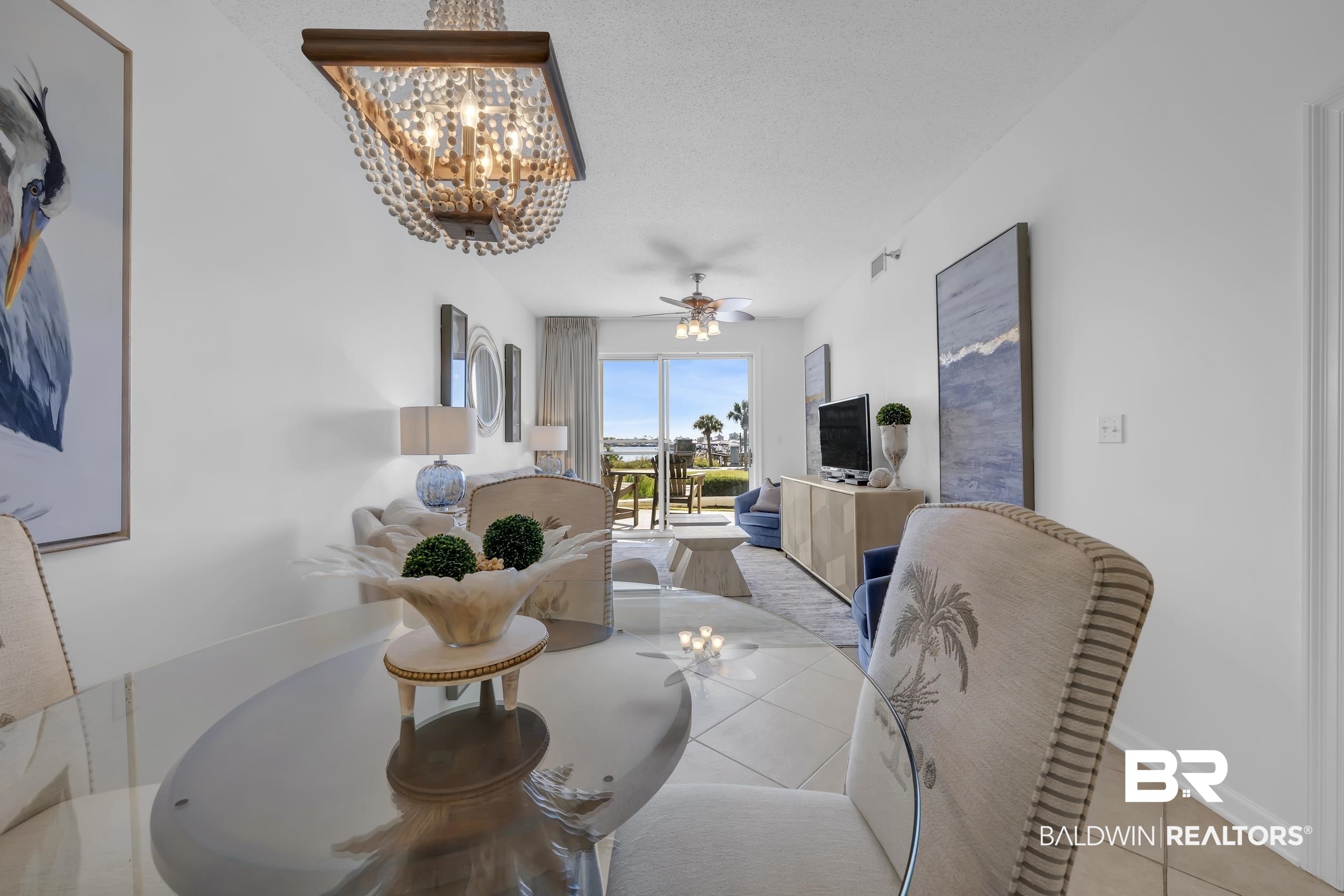 27282 Canal Road, Unit 104 Orange Beach, AL 36561 - Photo 11 of 79 Tiled dining space with a chandelier, a ceiling fan, and a textured ceiling