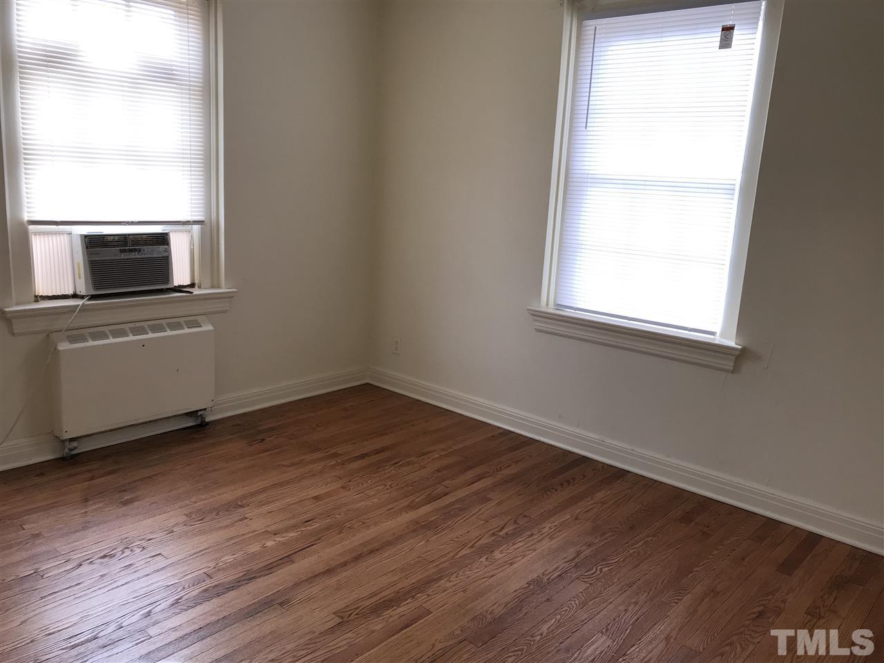 2402 Clark Avenue, Unit 10 Raleigh, NC 27607 - Photo 11 of 19 an empty room with wooden floor cabinet and windows