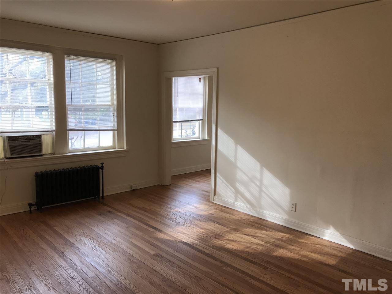 2402 Clark Avenue, Unit 10 Raleigh, NC 27607 - Photo 12 of 19 an empty room with wooden floor and windows