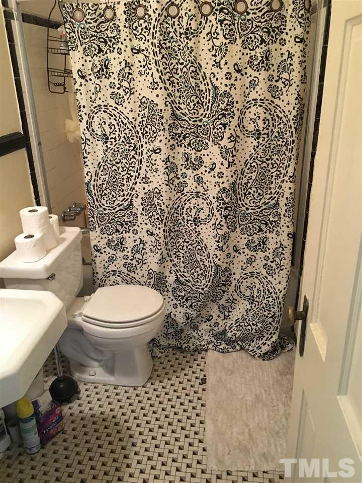 2402 Clark Avenue, Unit 10 Raleigh, NC 27607 - Photo 13 of 19 a white toilet sitting next to a shower curtain