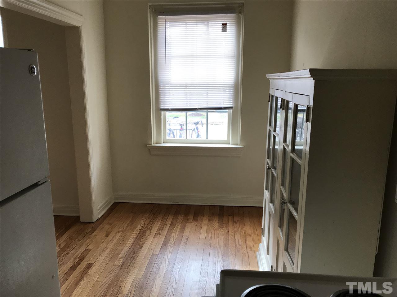 2402 Clark Avenue, Unit 10 Raleigh, NC 27607 - Photo 3 of 19 an empty room with wooden floor and windows