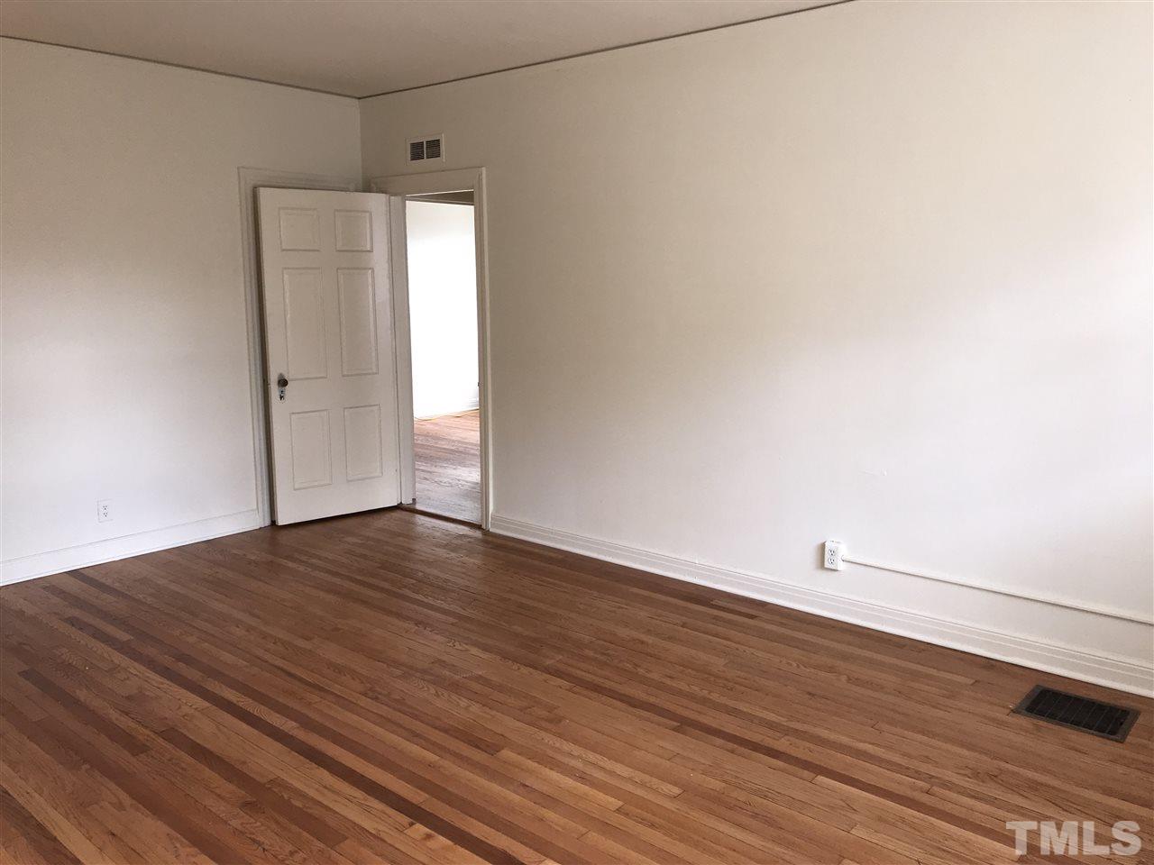 2402 Clark Avenue, Unit 10 Raleigh, NC 27607 - Photo 5 of 19 a view of an empty room with wooden floor and a window