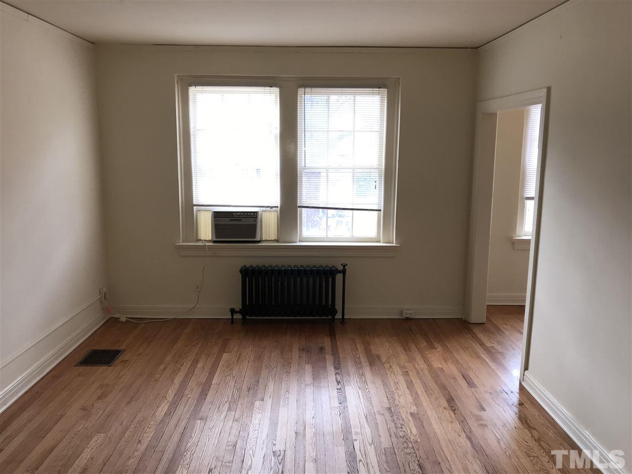 2402 Clark Avenue, Unit 10 Raleigh, NC 27607 - Photo 6 of 19 an empty room with wooden floor and windows