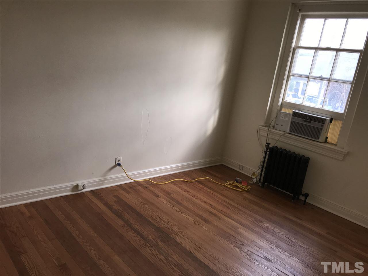 2402 Clark Avenue, Unit 10 Raleigh, NC 27607 - Photo 10 of 19 an empty room with wooden floor and windows