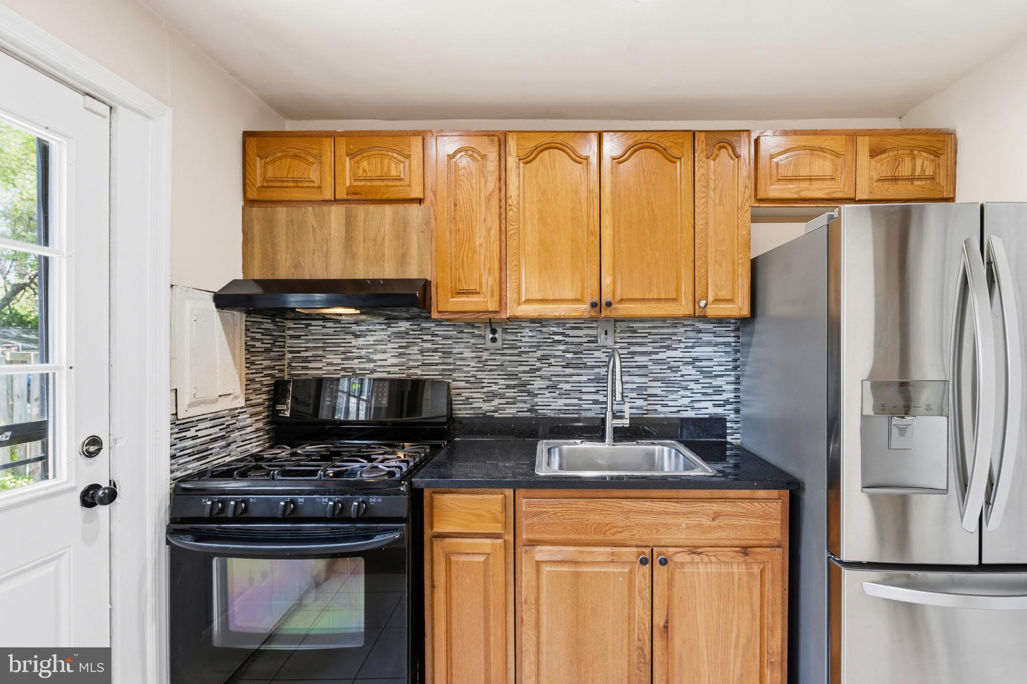 7204 East Inwood Street Landover, MD 20785 - Photo 12 of 24 a kitchen with granite countertop a refrigerator and a stove top oven