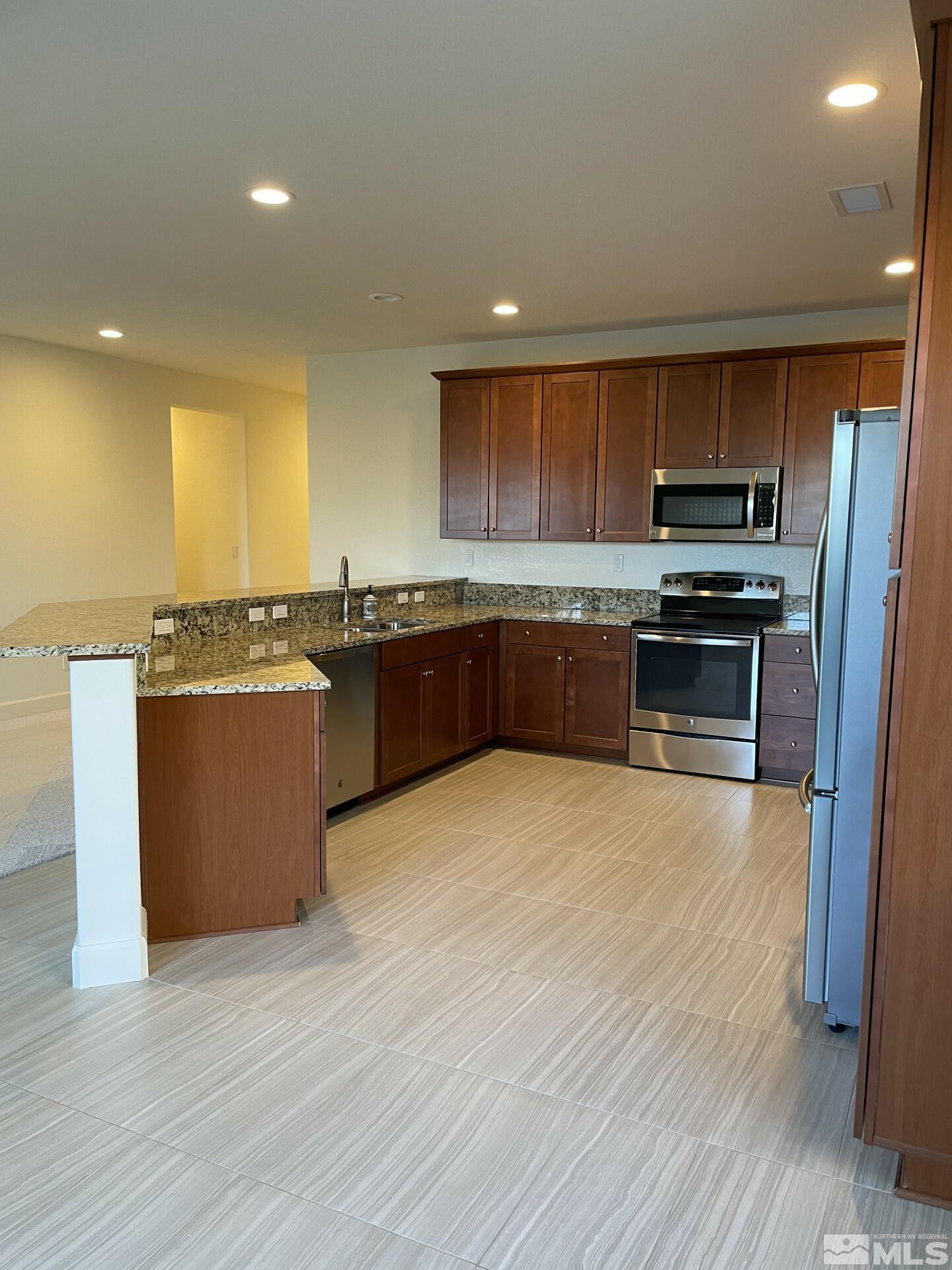 2087 Whitecliff Drive Reno, NV 89521 - Photo 3 of 33 a kitchen with stainless steel appliances granite countertop a stove a sink and a refrigerator