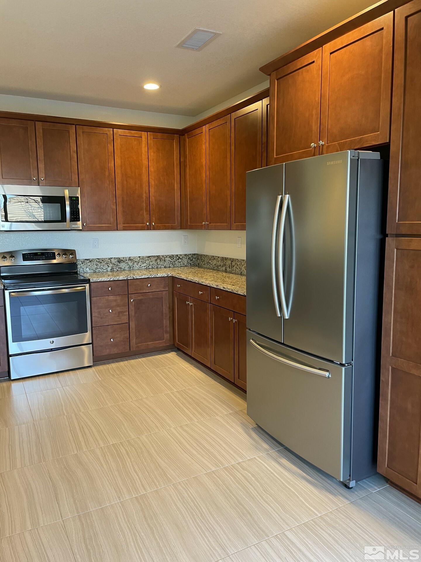 2087 Whitecliff Drive Reno, NV 89521 - Photo 4 of 33 a kitchen with stainless steel appliances granite countertop a refrigerator a sink and a stove