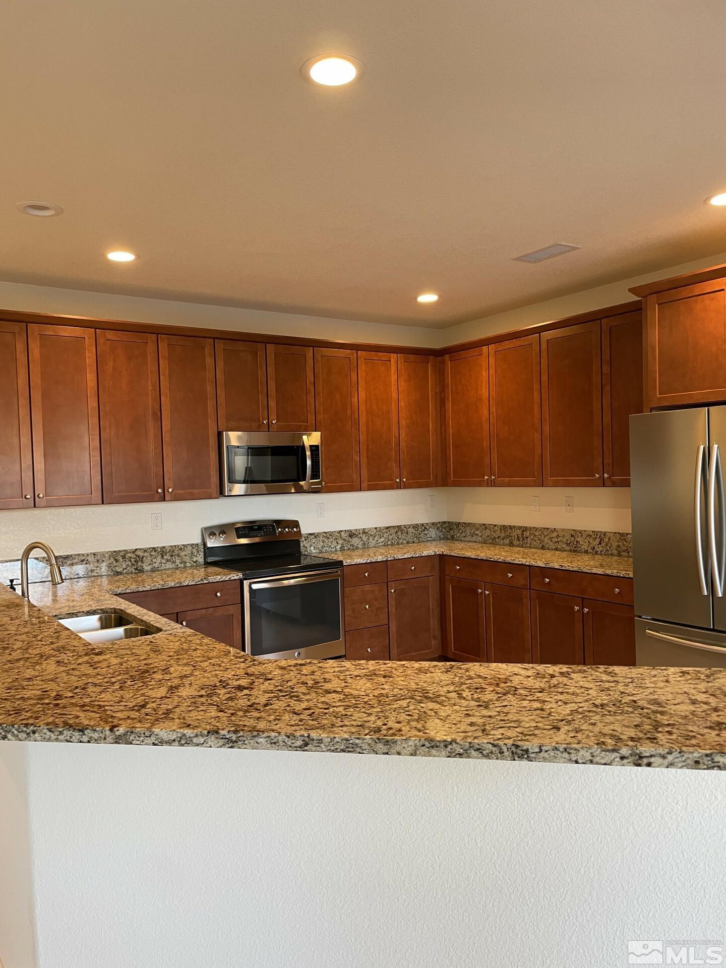 2087 Whitecliff Drive Reno, NV 89521 - Photo 6 of 33 a large kitchen with a stove a sink and a microwave