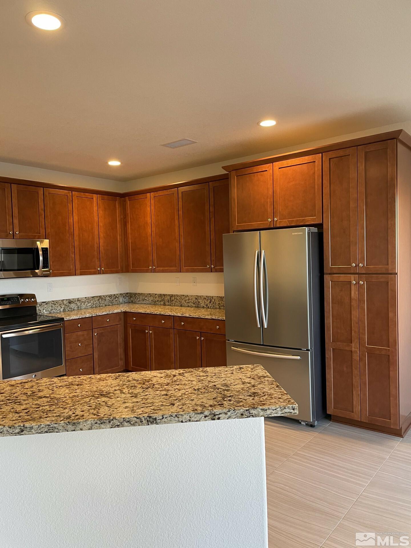 2087 Whitecliff Drive Reno, NV 89521 - Photo 7 of 33 a large kitchen with granite countertop a refrigerator and a sink