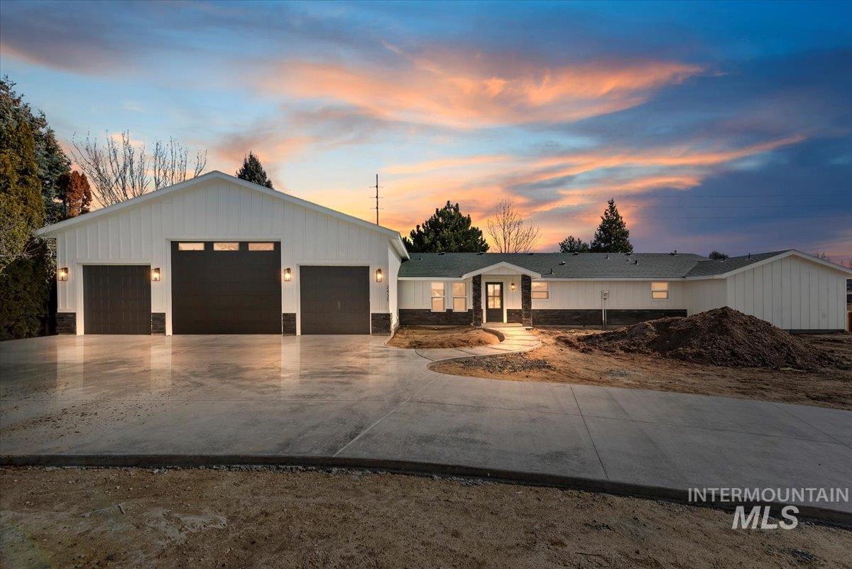 View of front of property with concrete driveway and an attached garage