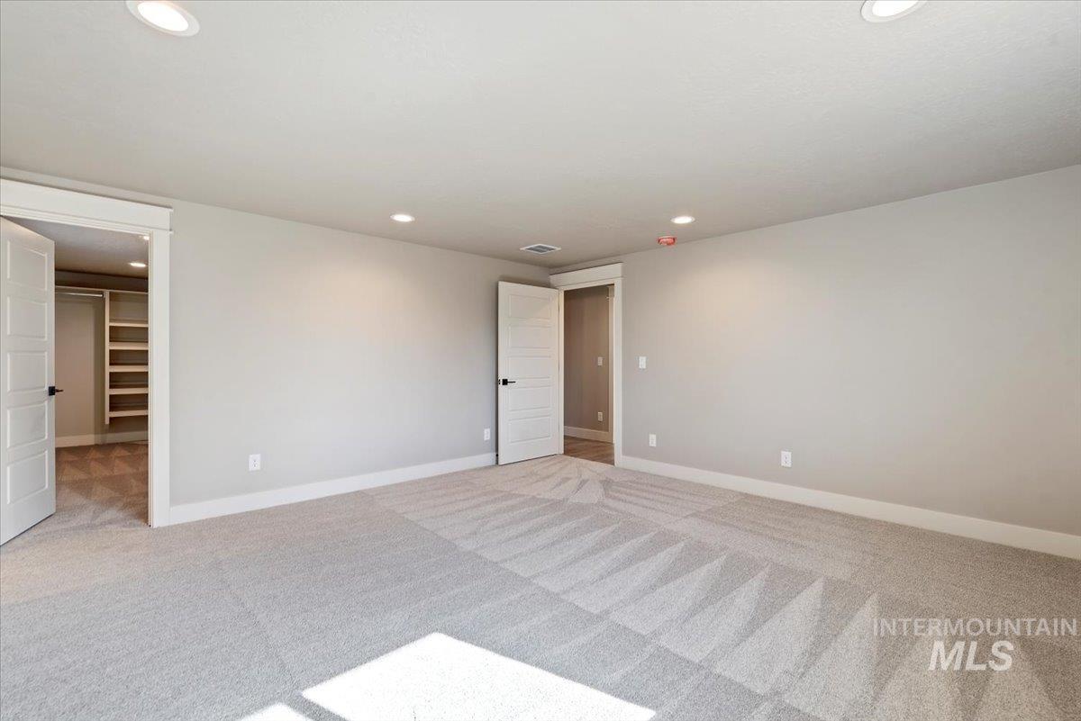 2435 North Black Cat Road Meridian, ID 83646 - Photo 13 of 32 Unfurnished bedroom with a walk in closet, light colored carpet, and recessed lighting