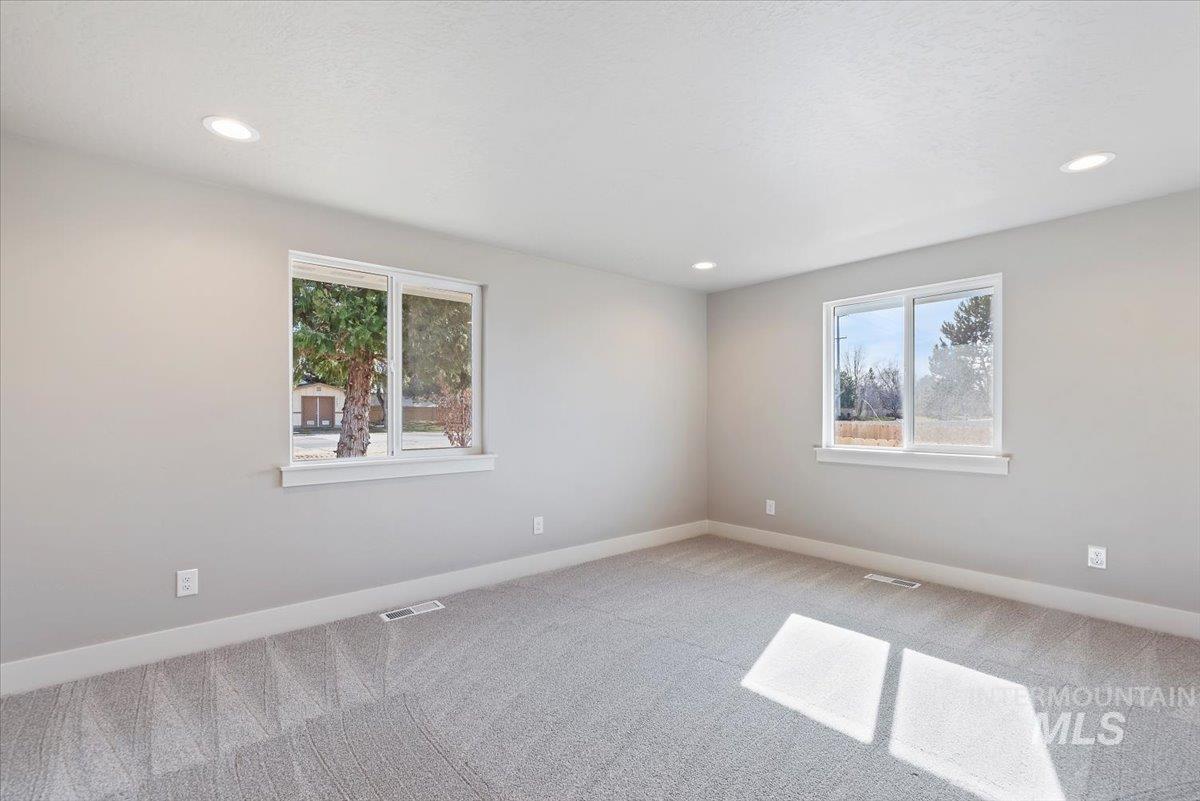 2435 North Black Cat Road Meridian, ID 83646 - Photo 14 of 32 Unfurnished room with carpet flooring, healthy amount of natural light, and recessed lighting