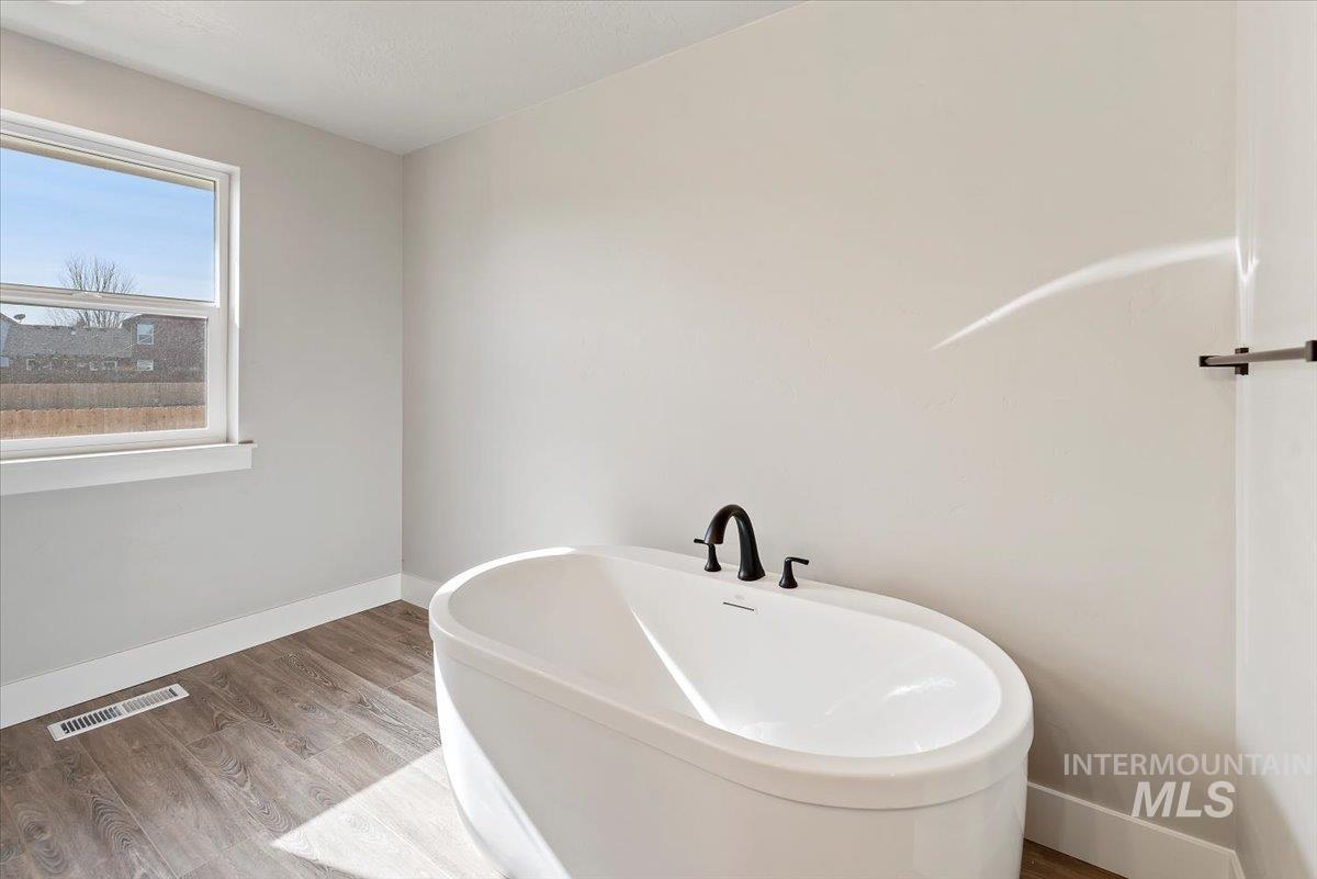 2435 North Black Cat Road Meridian, ID 83646 - Photo 17 of 32 Full bath featuring wood finished floors and a freestanding bath