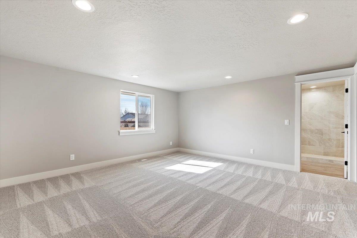 2435 North Black Cat Road Meridian, ID 83646 - Photo 19 of 32 Spare room featuring a textured ceiling, carpet flooring, and recessed lighting