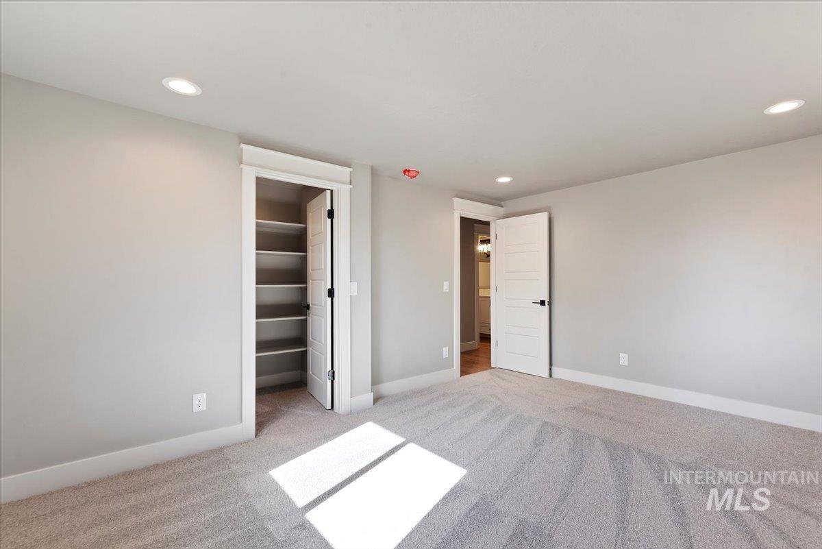 2435 North Black Cat Road Meridian, ID 83646 - Photo 23 of 32 Unfurnished bedroom with light colored carpet, a spacious closet, and recessed lighting