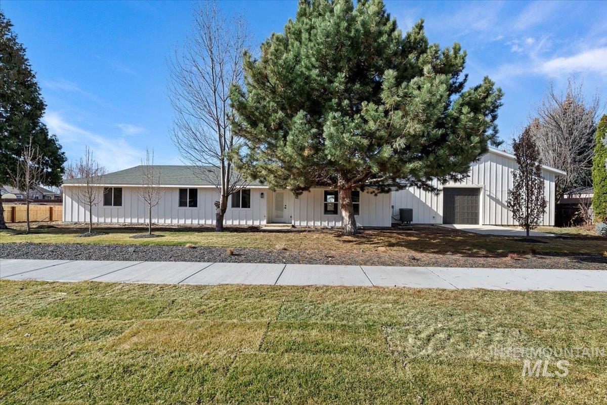 2435 North Black Cat Road Meridian, ID 83646 - Photo 31 of 32 View of front of property with covered porch, an attached garage, a front yard, and board and batten siding