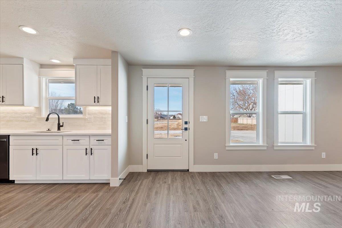 2435 North Black Cat Road Meridian, ID 83646 - Photo 4 of 32 Entryway with wood finished floors, a textured ceiling, and recessed lighting