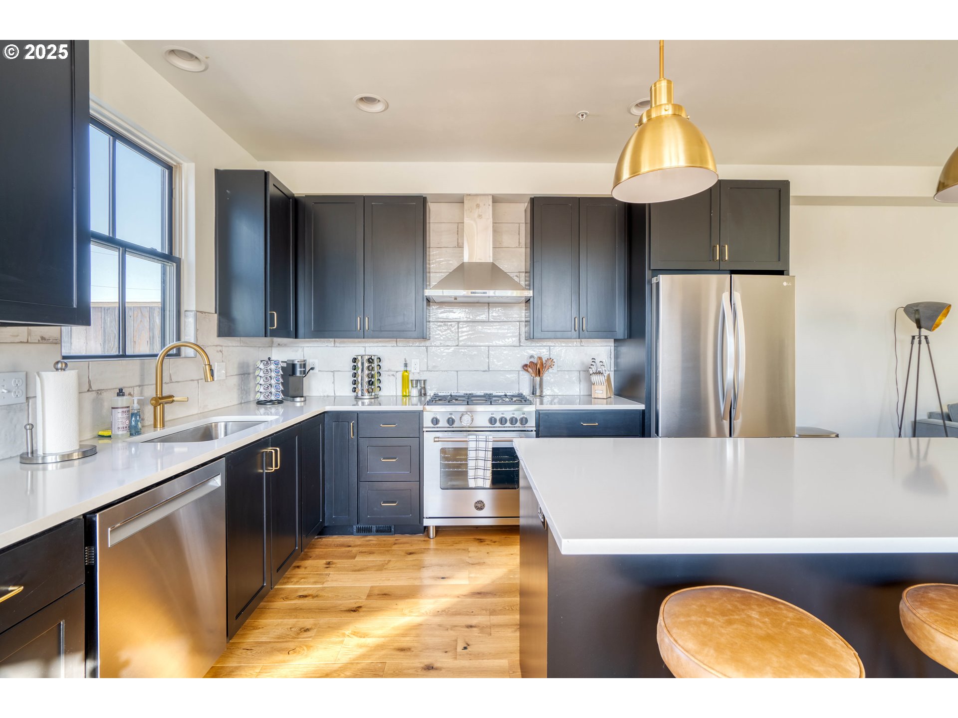 508 Northeast 56th Avenue Portland, OR 97213 - Photo 10 of 38 a kitchen with stainless steel appliances granite countertop a refrigerator a sink dishwasher a stove and white countertops with wooden floor