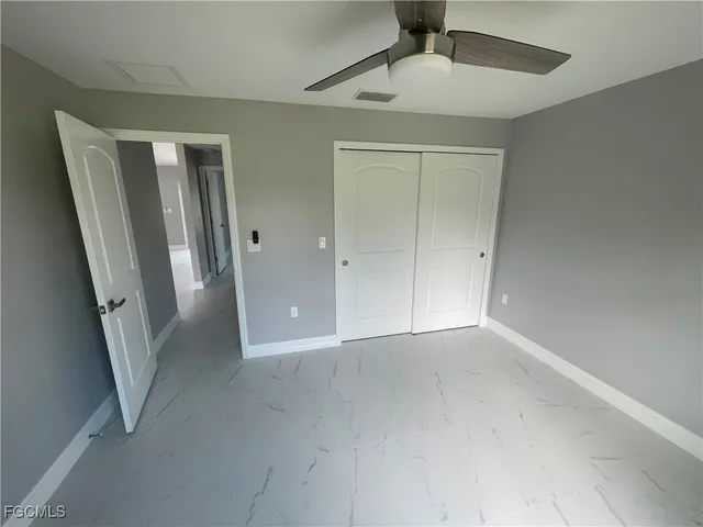 an empty room with a staircase and a ceiling fan view