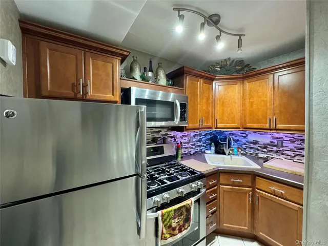 a kitchen with stainless steel appliances granite countertop a refrigerator and a stove
