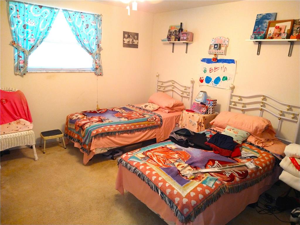 8415 Briarleaf Court Port Richey, FL 34668 - Photo 12 of 27 a bedroom with two beds and a couch