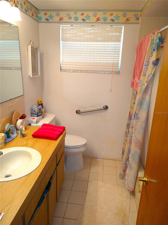 8415 Briarleaf Court Port Richey, FL 34668 - Photo 13 of 27 a bathroom with a sink a toilet and shower curtain