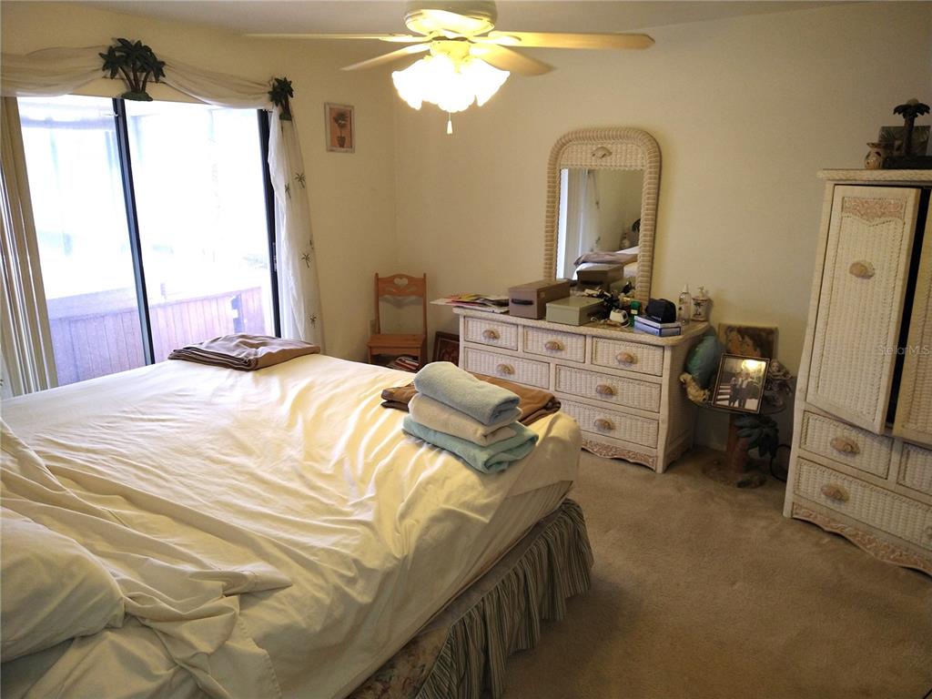 8415 Briarleaf Court Port Richey, FL 34668 - Photo 15 of 27 a bedroom with a bed a chandelier and mirror on the dresser