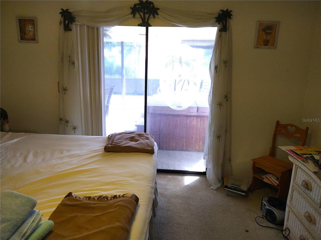 8415 Briarleaf Court Port Richey, FL 34668 - Photo 18 of 27 a bedroom with a bed and wooden floor