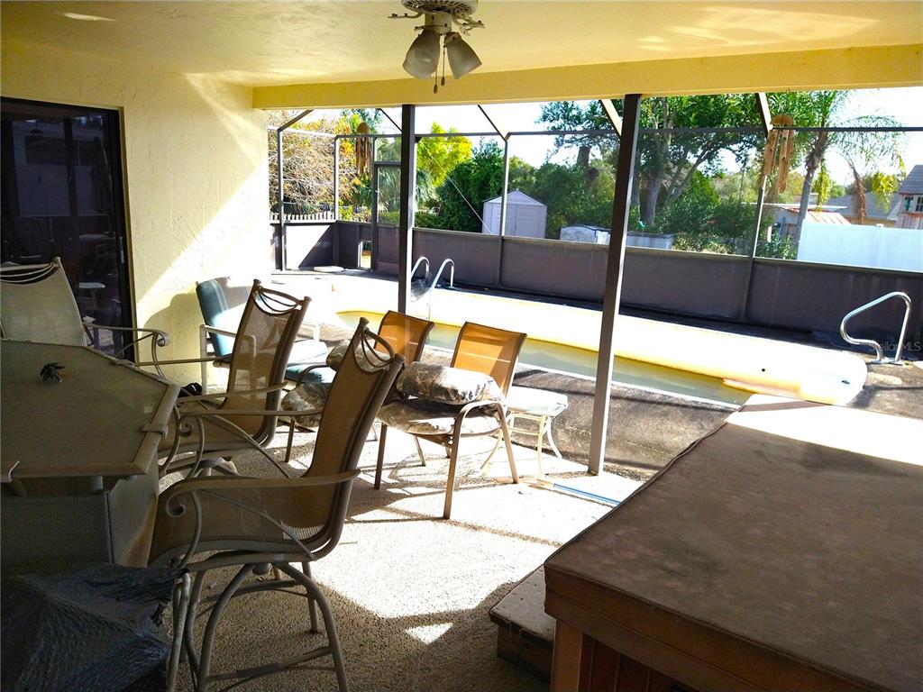 8415 Briarleaf Court Port Richey, FL 34668 - Photo 19 of 27 a view of a patio with table and chairs floor to ceiling window with wooden floor