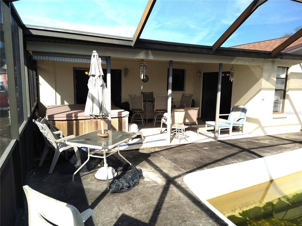 8415 Briarleaf Court Port Richey, FL 34668 - Photo 22 of 27 a view of a patio with table and chairs with wooden floor