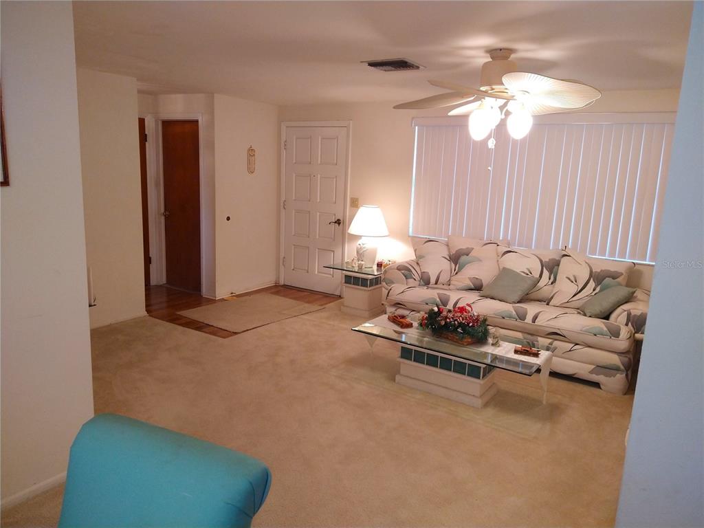 8415 Briarleaf Court Port Richey, FL 34668 - Photo 4 of 27 a living room with furniture and a chandelier
