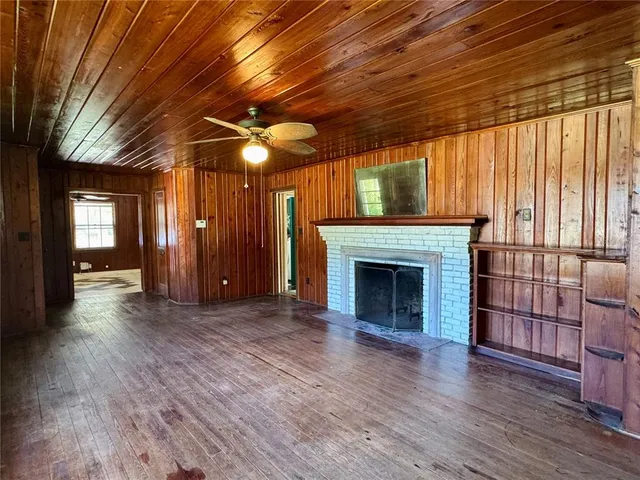 a view of empty room with wooden floor and fireplace