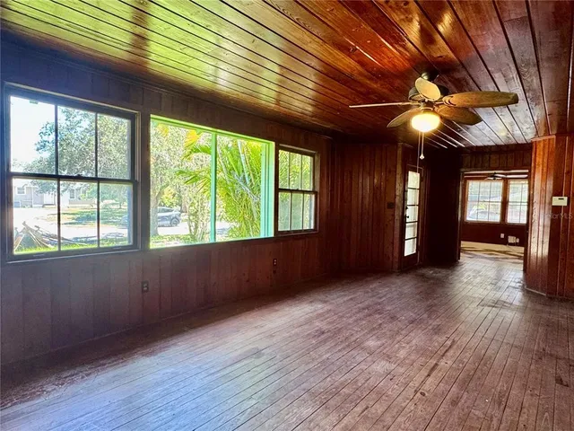 a view of an empty room with window and wooden floor