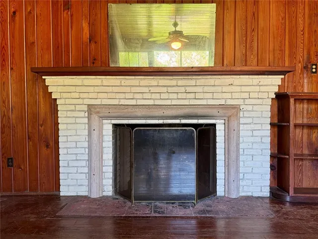 a view of a livingroom with wooden floor and a fireplace