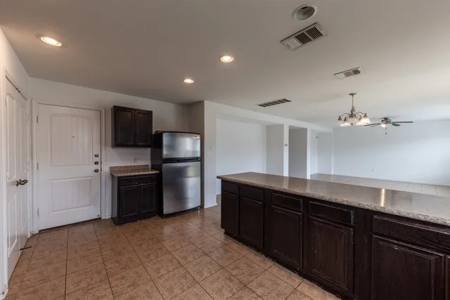 a kitchen with stainless steel appliances granite countertop a refrigerator and a sink