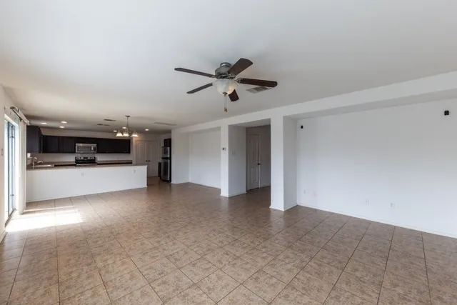 a view of empty room with a kitchen