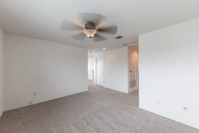 an empty room with a window and a ceiling fan