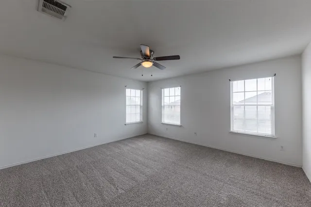 an empty room with closet and windows