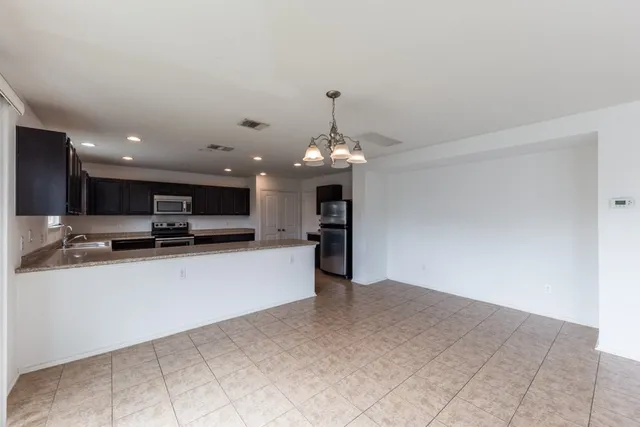 a view of a kitchen with kitchen island a sink stainless steel appliances and cabinets