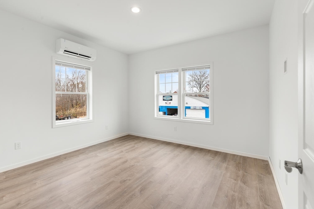 50 R Maplewood Avenue, Unit 215 Gloucester, MA 01930 - Photo 13 of 14 an empty room with windows and mirror