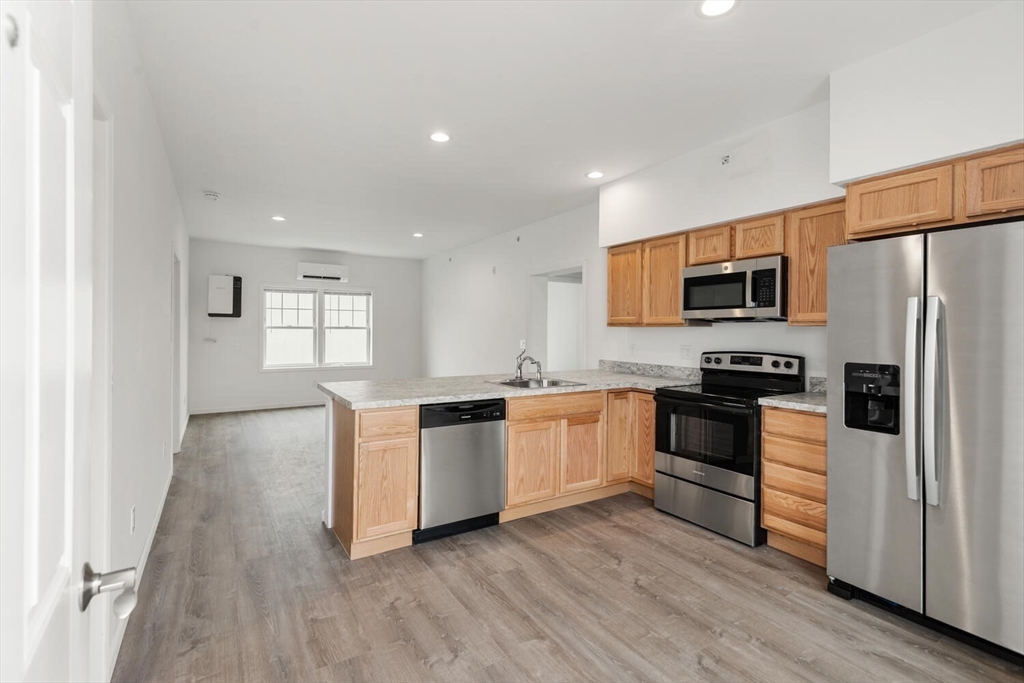50 R Maplewood Avenue, Unit 215 Gloucester, MA 01930 - Photo 2 of 14 a kitchen with granite countertop a refrigerator stove top oven and sink