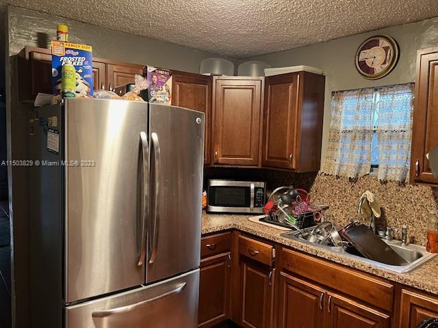1755 Northwest 69th Street Miami, FL 33147 - Photo 14 of 36 a kitchen with a refrigerator and a sink