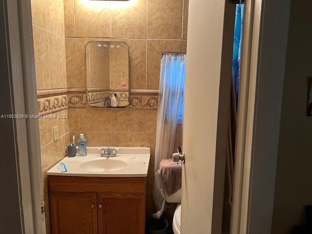 1755 Northwest 69th Street Miami, FL 33147 - Photo 21 of 36 a bathroom with a sink and mirror with toilet