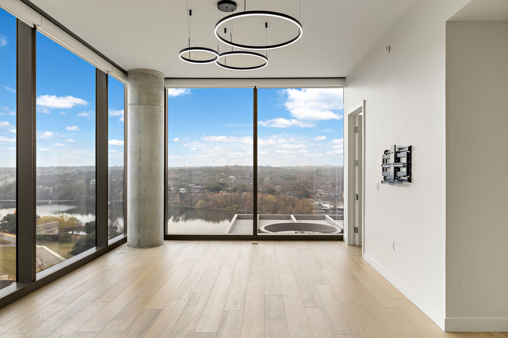 44 East Avenue, Unit 1210 Austin, TX 78701 - Photo 2 of 40 Living room featuring expansive windows, light wood finished floors, healthy amount of natural light, and a water view