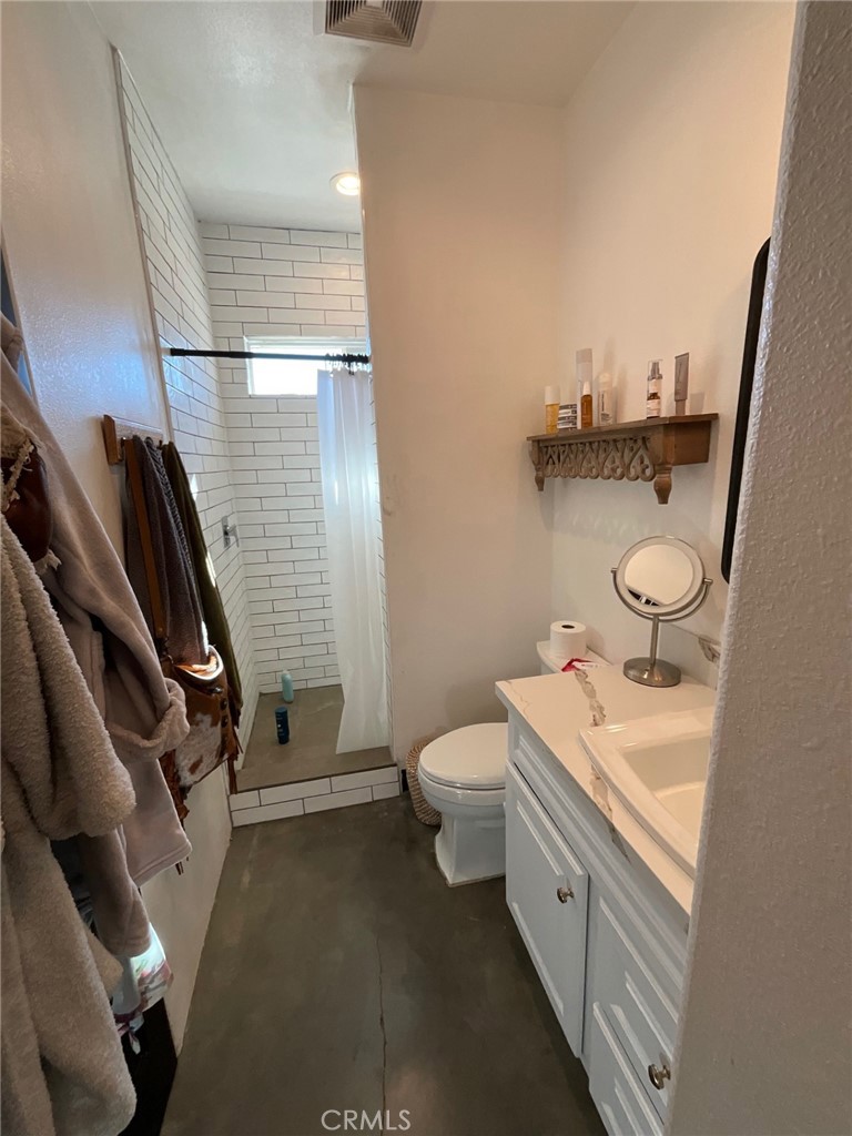 10773 Mills Road Apple Valley, CA 92308 - Photo 28 of 39 a bathroom with a granite countertop toilet sink and mirror