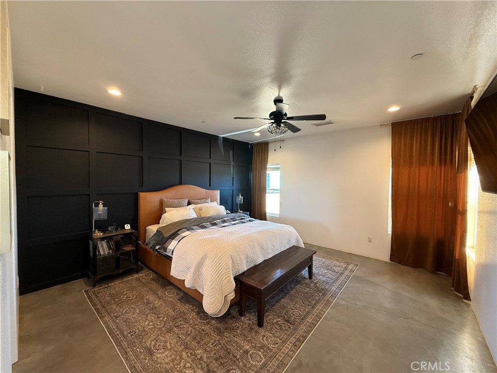 10773 Mills Road Apple Valley, CA 92308 - Photo 32 of 39 a bed room with a bed and a ceiling fan