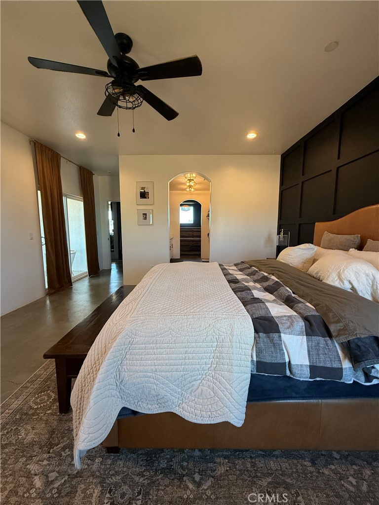 10773 Mills Road Apple Valley, CA 92308 - Photo 35 of 39 a bedroom with a large bed and a chandelier