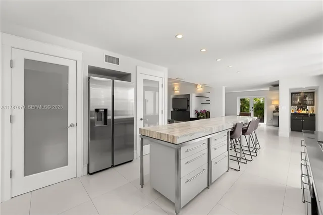 a kitchen with white cabinets and refrigerator