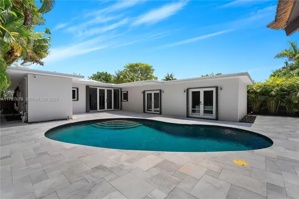 a view of pool with lawn chairs and plants
