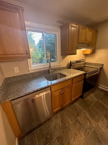 a kitchen with stainless steel appliances granite countertop a sink stove and cabinets